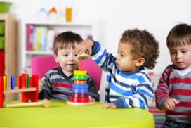 Two young children playing with a toy tower.